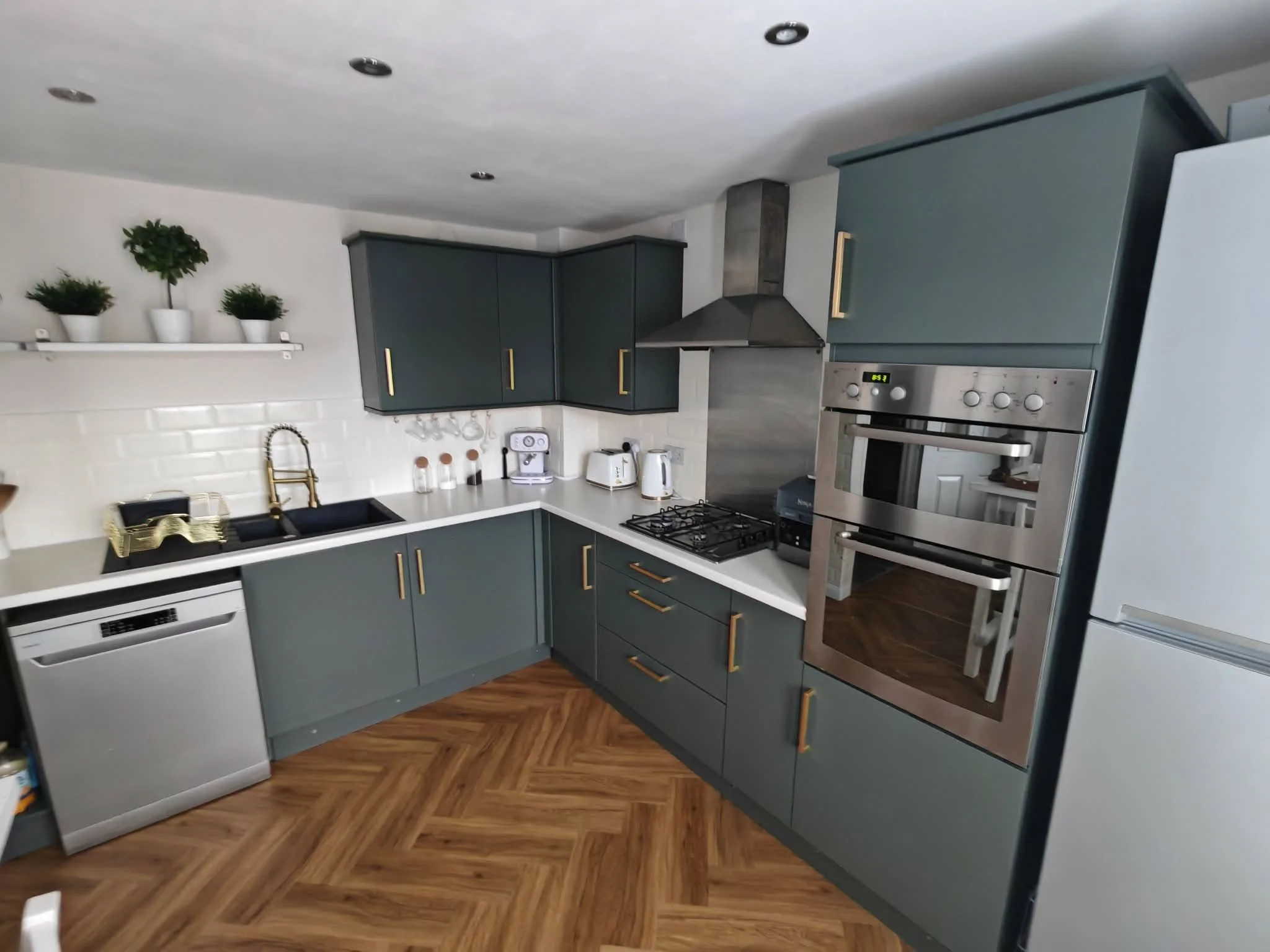 Sage green respray fitted kitchen with gold handles, an example of UPVC and cupboard spraying by Colour Medic